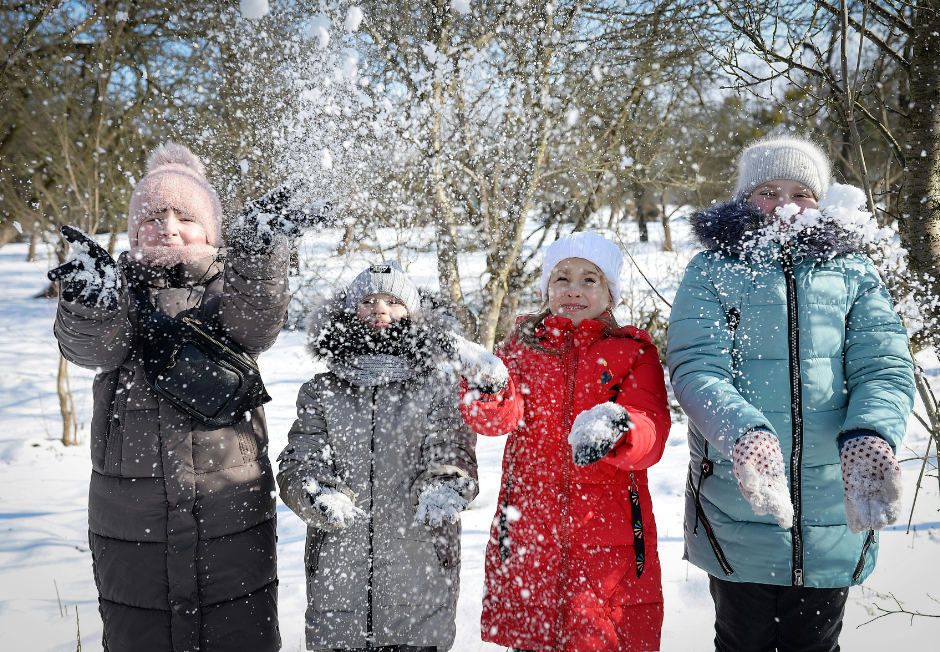 Zdjęcie przedstawia grupę dzieci bawiącą się śniegiem